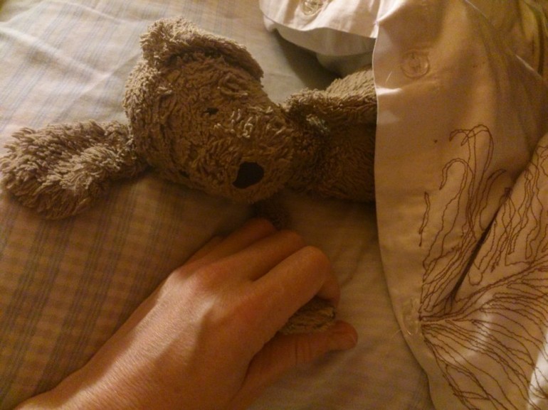 Comfort toy asleep in bed holding my hand, October 2013, Helen Sargeant ©